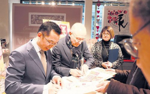 　　盧沙野大使(左)、菲利普·瓦爾總裁為集郵愛(ài)好者簽名留念。(《歐洲時(shí)報(bào)》/歐文 攝)