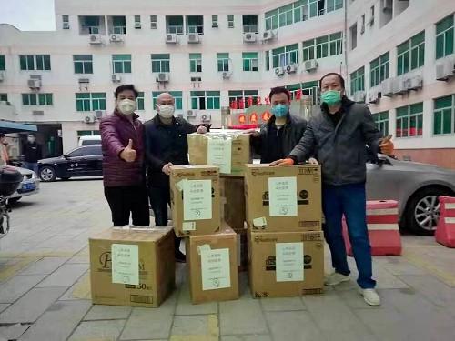 福清華僑中學(xué)日本校友會捐贈的的防疫物資由福清市紅十字會交到福清華僑中學(xué)老師手上。(福清華僑中學(xué)供圖) 