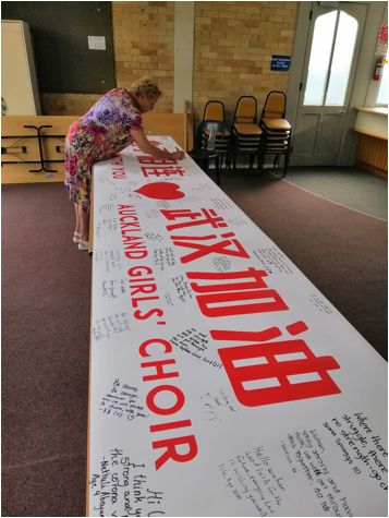 橫幅上寫(xiě)滿(mǎn)了女孩兒們對(duì)武漢的祝福