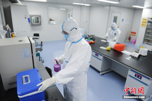 3月12日，核酸檢測人員在給標本轉(zhuǎn)運箱消毒。<a target='_blank' >中新社</a>記者 張婭子 攝