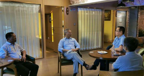 ?？谑袃S聯(lián)主席陳文培(中)與日本海南總商會會長符明潮(左)交流僑企復(fù)工有關(guān)情況。(陳德壯 攝)