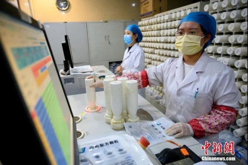 3月24日，山西省太原市，醫(yī)務(wù)人員使用機(jī)器調(diào)配中醫(yī)藥劑。這些藥品經(jīng)裝箱后將發(fā)往海外，助力僑胞抗擊疫情。<a target='_blank' >中新社</a>記者 韋亮 攝