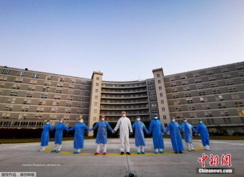 當?shù)貢r間4月6日，意大利克雷莫納一家醫(yī)院的醫(yī)務(wù)人員手牽手，向在新冠肺炎疫情中受影響的人們表示支持和致意。