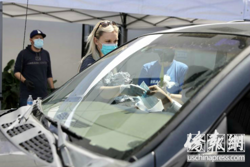 夢想中心的義工在給低收入者發(fā)放口罩。(美國《僑報》/邱晨 攝)