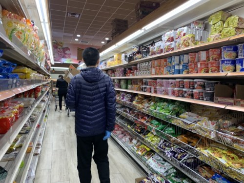 部份連鎖超市暫時關(guān)閉期仍開放外送服務(wù)，圖為超市業(yè)者手持訂單，為顧客選購商品。(美國《世界日報》/賴蕙榆 攝)