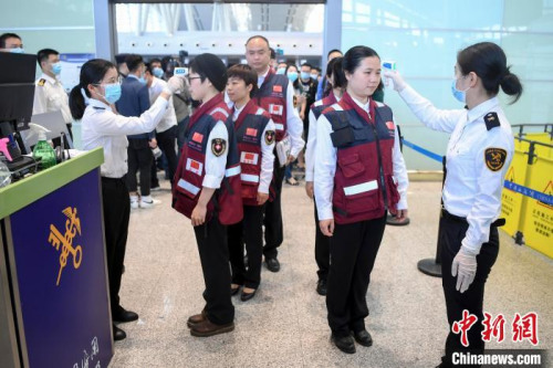 醫(yī)療專家通過海關(guān)測(cè)量體溫。　楊華峰 攝