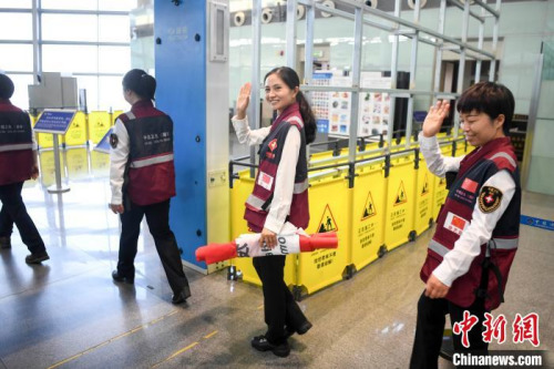 醫(yī)療專家向送行人員走揮手告別。　楊華峰 攝