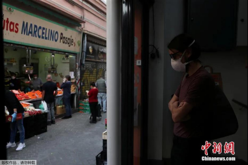 當(dāng)?shù)貢r間5月4日起，西班牙絕大部分地區(qū)進入分階段降級封禁措施的準(zhǔn)備階段，部分小商鋪重新開業(yè)。圖為戴口罩的男子在水果攤前保持社交距離。(<a target='_blank'  >中新網(wǎng)</a>)
