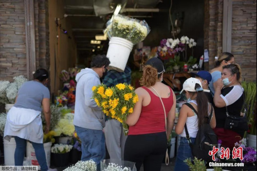 美國多地商店恢復(fù)營業(yè)，花市生意紅火。當(dāng)?shù)貢r間5月8日，美國加利福尼亞州洛杉磯市，當(dāng)?shù)夭糠稚虡I(yè)開始恢復(fù)營業(yè)，人們在洛杉磯花區(qū)購物。