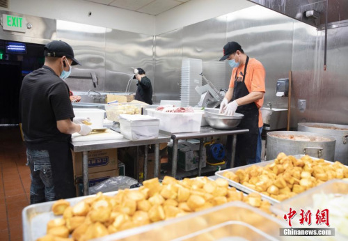 廚師們忙著制作各自負(fù)責(zé)的食品。<a target='_blank' >中新社</a>記者 劉關(guān)關(guān) 攝