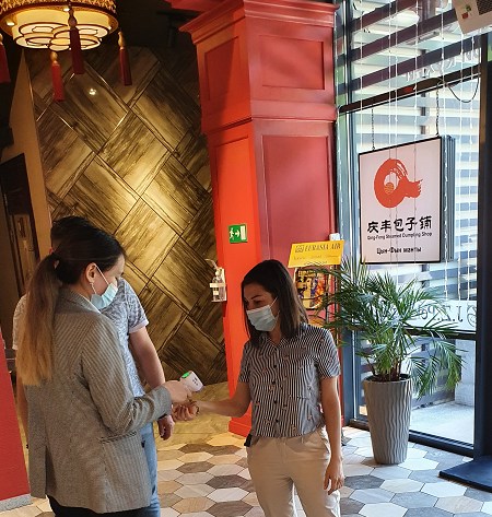 “九澤烤鴨”專設(shè)服務(wù)員給進(jìn)店顧客測(cè)量體溫。(“哈薩克斯坦新觀察”微信公眾號(hào))