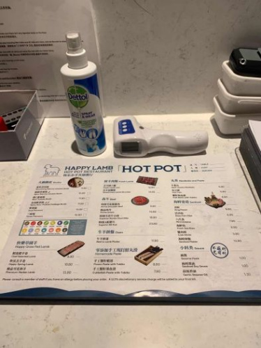 　▲快樂小羊準(zhǔn)備的“防疫三寶”：噴灑客人身上的消毒噴霧、體溫檢測儀和一次性菜單。(受訪者提供)