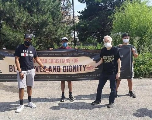 華人和黑人在同一條橫幅標語前合影。(《芝加哥華語論壇》 張大衛(wèi) 攝)