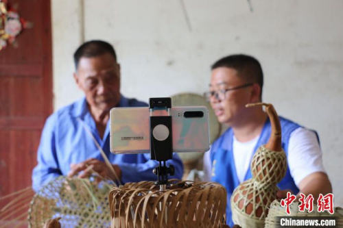 梁福年通過網(wǎng)絡(luò)直播方式幫助蘇國厚銷售竹編助增收?！＄婙Q 攝