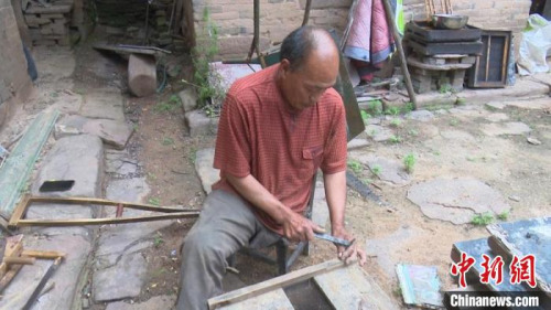 圖為秦森林正在釘蜂箱?！?jiān)?攝