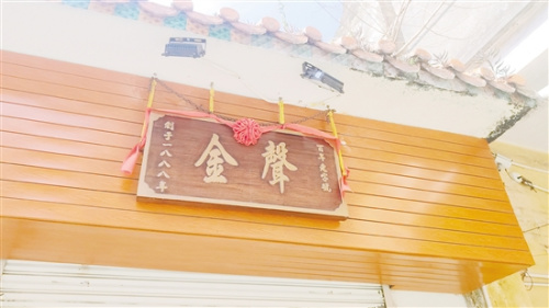 這塊質(zhì)地堅硬的木質(zhì)“金聲”牌匾，默默見證著獅鼓行業(yè)的前世今生。