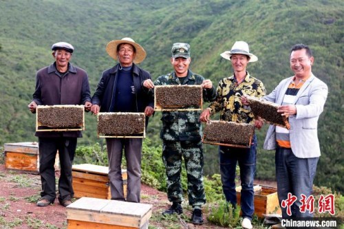 布哈與村民展示養(yǎng)蜂成果。圖片由武警部隊(duì)提供