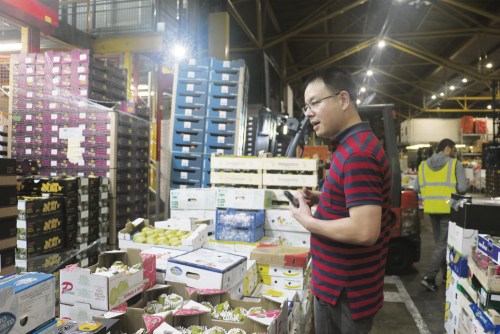 熊鵬在市場跟老板詢價。（《歐洲時報》/田皓雪子 攝）