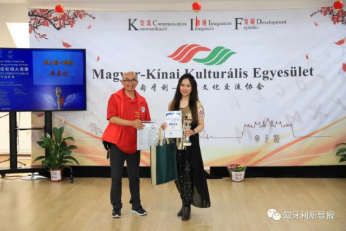 匈中文化交流協(xié)會(huì)會(huì)長(zhǎng)滕維杰（左）為成人組一等獎(jiǎng)獲得者李嘉欣頒獎(jiǎng)。（匈牙利《新導(dǎo)報(bào)》）