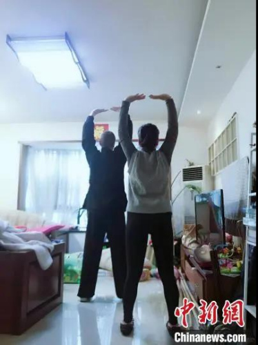 馬丁教妻子練習(xí)八段錦。