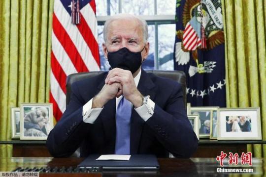 圖為美國總統(tǒng)拜登在華盛頓白宮橢圓形辦公室簽署行政命令。