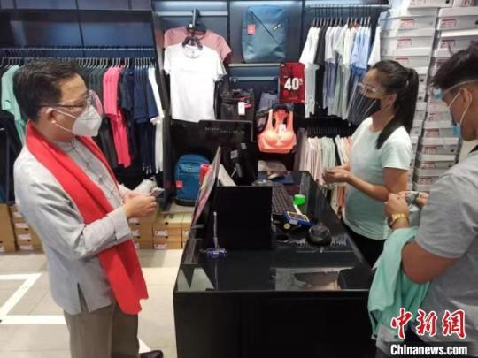 黃溪連大使當(dāng)場購買商品，支持中菲商業(yè)發(fā)展。中國駐菲律賓使館供圖