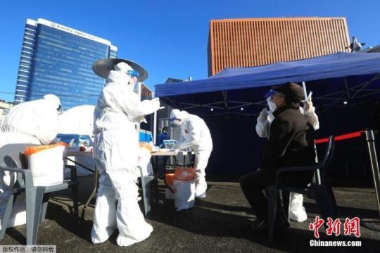 資料圖：2020年12月14日，韓國首爾，醫(yī)務(wù)人員對市民進(jìn)行新冠病毒檢測。