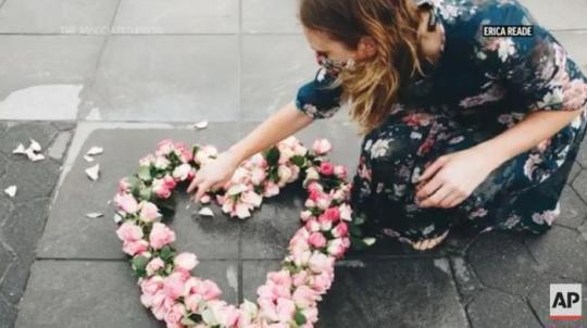 美國藝術(shù)家莉比在紐約放置花朵展品。圖片來源：美聯(lián)社新聞視頻截圖。