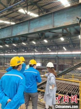 圖為羅小穎(右一)查看鋼材廠。羅小穎 供圖