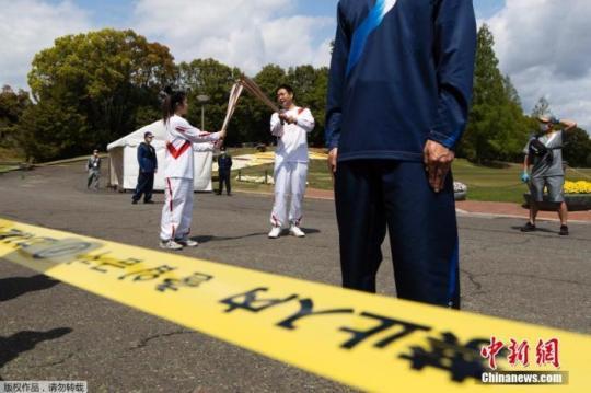 當?shù)貢r間4月13日，日本大阪，東京奧運會圣火在大阪府傳遞。受新冠疫情影響，圣火傳遞時卻是這樣一幅景象：火炬手舉著火炬從一個空蕩蕩的公園穿過，周圍十分冷清。