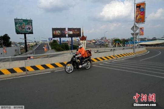 資料圖：當(dāng)?shù)貢r(shí)間4月16日，柬埔寨金邊，一名食品配送員在空蕩蕩的馬路上行駛。柬埔寨政府14日晚宣布，首都金邊和干拉省大金歐市從4月15日零時(shí)起“封城”14天，直至4月28日。除“重要服務(wù)”領(lǐng)域，任何人不得隨意外出。
