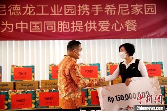 圖為徐捷向希尼家園負(fù)責(zé)人佟桐女士提供愛心支票?！∮∧岬慢埞I(yè)園 供圖