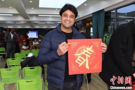 圖為留學(xué)生展示自己寫的“春”字，感受中國(guó)年文化。　西北師范大學(xué)國(guó)際文化交流學(xué)院供圖