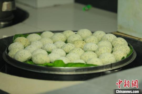 制作好的清明粑放在葉子上，并放在鍋里蒸熟?！±铤Q 攝