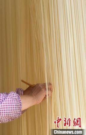 村民用面筷輕輕撥開爽面，避免粘連?！⊥鮿?攝
