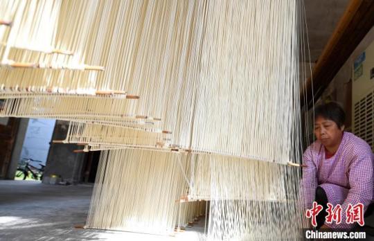 村民適當(dāng)下拉即將晾曬的爽面?！⊥鮿?攝