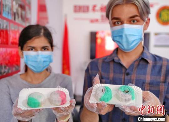 圖為外國(guó)留學(xué)生展示制作完成的月餅?！〔芙ㄐ?攝