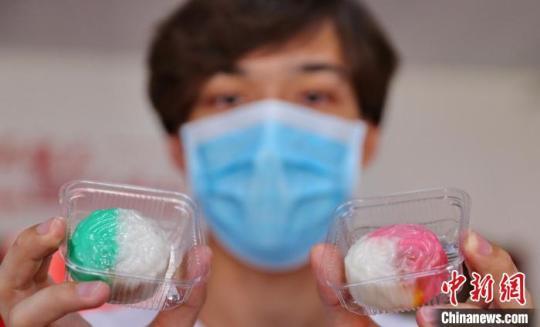 圖為外國(guó)留學(xué)生展示制作完成的月餅?！〔芙ㄐ?攝