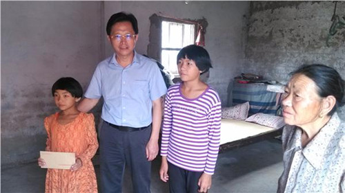 省僑辦紀(jì)檢組長周林代表省僑辦向貧困家庭送上慰問金