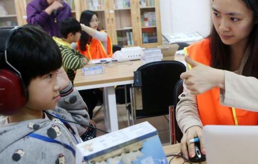 中國僑網(wǎng)圖為聽障兒童正在“試用”。