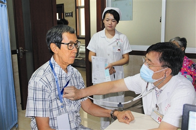 醫(yī)生為僑胞體檢。（深圳僑報/張平和
