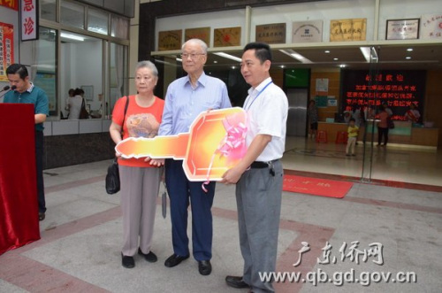 霍先生夫婦向醫(yī)院院長羅錫(右一)交接捐贈救護車鑰匙