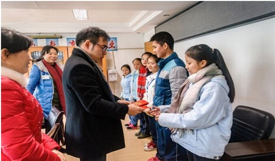 中國僑網(wǎng)圖為趙興先生為學(xué)生發(fā)放助學(xué)金