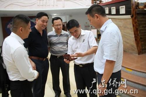 中國僑網(wǎng)鄭建民副主任(中)、廣東華僑博物館館長王明惠(右二)與朱金亮?xí)L(右一)等仔細(xì)研看收藏品