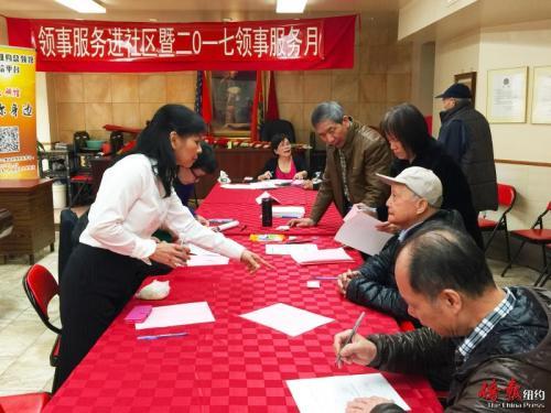 中國僑網(wǎng)紐約總領(lǐng)館領(lǐng)事指導(dǎo)耆老填表。(美國《僑報(bào)》/葉永康 攝)