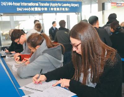 中國僑網(wǎng)圖為過境旅客在北京首都國際機場T3航站樓辦理手續(xù)。羅曉光攝(新華社發(fā))