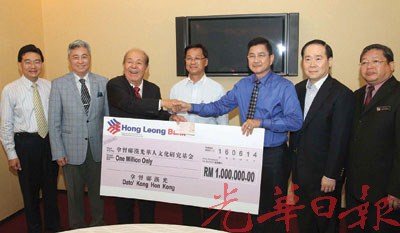 鄺漢光(右3)移交百萬令吉捐獻予吳德芳(左3),由方天興(中)見證。(馬來西亞《光華日報》)