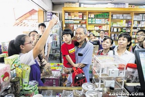 82歲的謝榮明(中)攜孫子參與中藥學(xué)習(xí)之旅時,聆聽加?xùn)|修道院女校的“小導(dǎo)游”分享基本中藥知識和藥行的歷史。(新加坡《聯(lián)合早報(bào)》/龍國雄