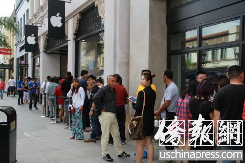中國僑網(wǎng)搶購iPhone新款手機(jī)的“果粉”在蘋果手機(jī)專賣店前排長龍。(美國《僑報》/周慧一 攝)
