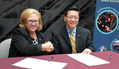 中國僑網(wǎng)史維會主席王裕佳(右)與多倫多天主教教育局總監(jiān)高蒂伊正式簽署“合作備忘錄”。(美國《世界日報》/謝君 攝)